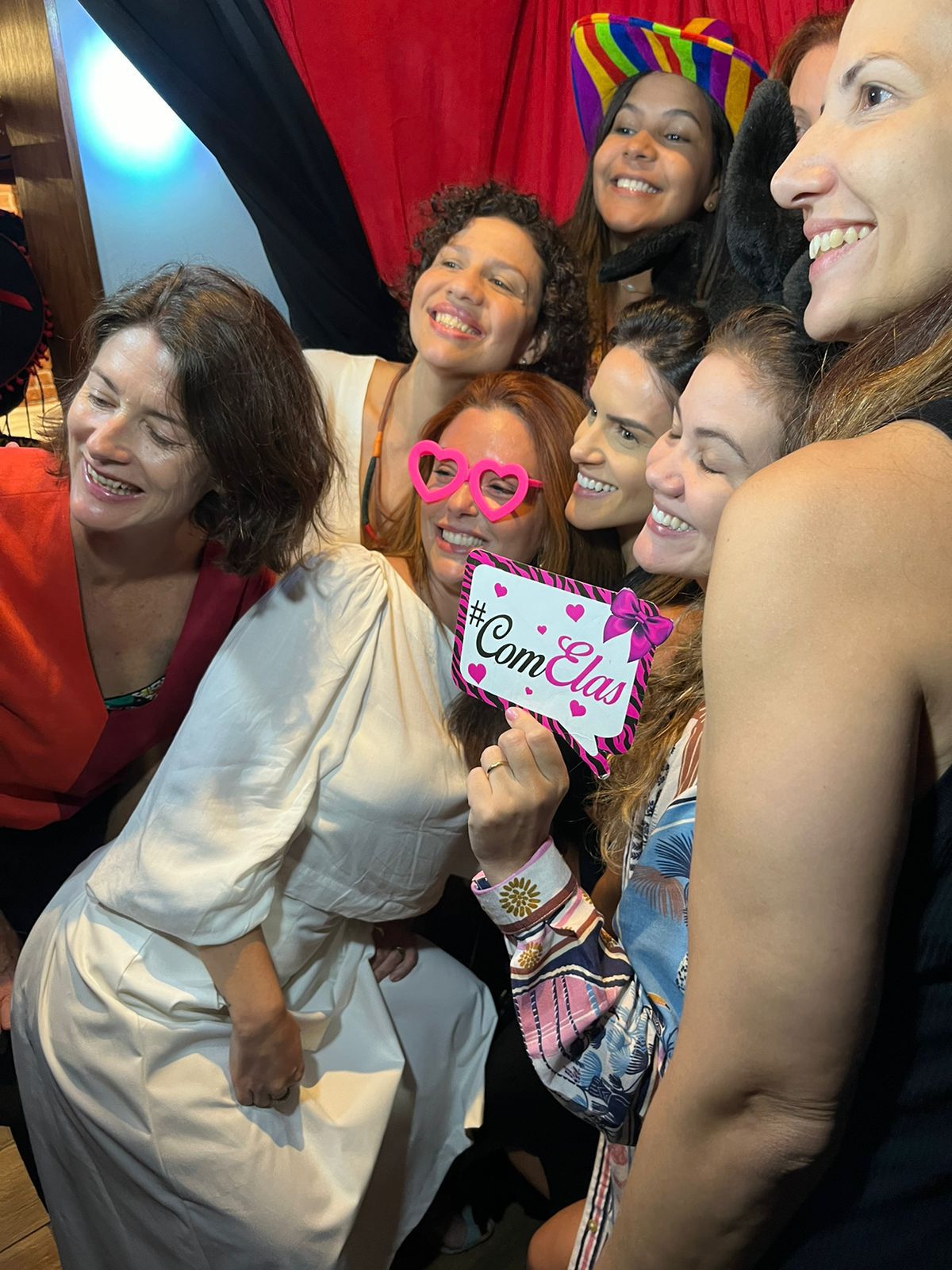 Convidados rindo juntos dentro da foto cabine